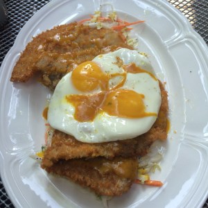 Pork schnitzel with coleslaw, poppy seed dressing, Carolina barbeque & fried eggs